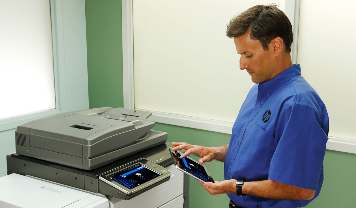 man servicing an HP printer
